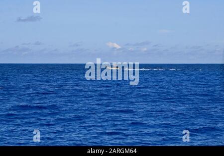 Bateau de pêche en mer, au large de la côte de la baie St Anne, Ile Praslin, Seychelles. Banque D'Images