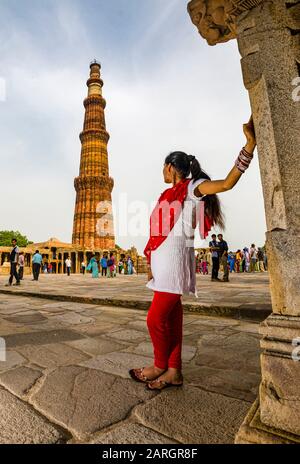 Jeune femme regardant Qutub Minar, également connue sous le nom de Qutb Minar et Qutab Minar, un ancien monument islamique à Delhi Banque D'Images