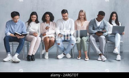 Jeune groupe international de personnes en attente d'entrevue d'emploi Banque D'Images