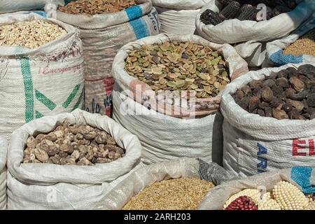 Sacs de Corncobs, haricots secs, figues et divers légumes et herbes sur un marché à Chivay, au Pérou Banque D'Images