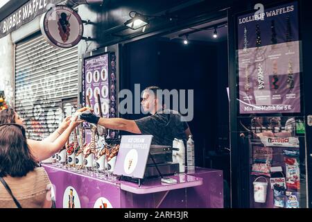 Londres/Royaume-Uni - 17 juillet 2019 : femme achetant des gaufres à bulles dans un stand de Camden High Street à Camden Town. Originaire de Hong Kong, ce que l'on appelle le waffl des œufs Banque D'Images