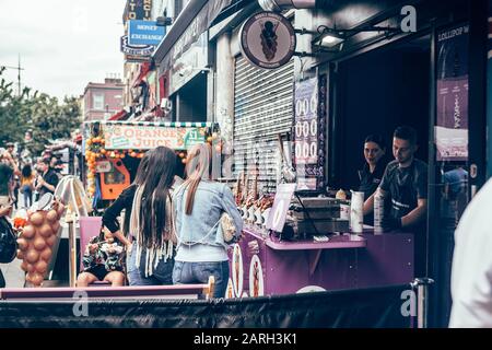 Londres/Royaume-Uni - 17 juillet 2019 : les femmes achetant des gaufres à bulles dans un stand de Camden High Street à Camden Town. Originaire de Hong Kong, ce que l'on appelle le waffl des œufs Banque D'Images