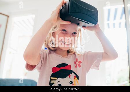 femme enfant à l'intérieur à l'aide de la visionneuse tridimensionnelle – bonheur, avenir, concept de jeu vidéo Banque D'Images