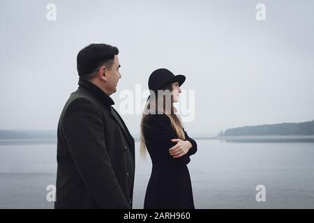 Jeune couple dans une relation troublée un lac brouillard froid en hiver Banque D'Images