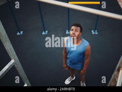 Vue en grand angle d'un jeune homme sportif qui se prépare à faire des pull-up sur un bar à la salle de gym extérieure dans le parc - copyspace Banque D'Images