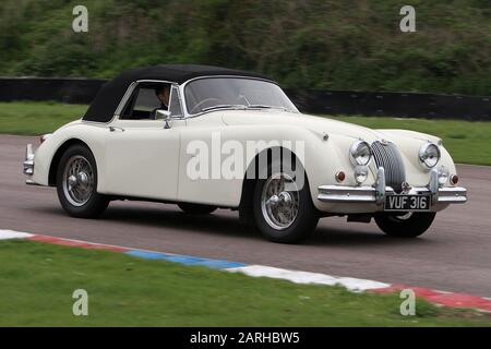 Une Jaguar XK150 1958 conduit autour du circuit de course de Thruxton dans le Hampshire en Angleterre en 2006. Banque D'Images