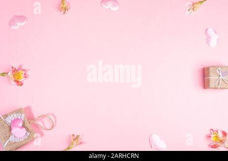 Cadre de sac à main décoratif en osier, boîte cadeau emballée à la maison, coeurs roses, fleurs d'Alstroemeria sur fond rose. Saint-Valentin, Journée de la femme ou Moth Banque D'Images