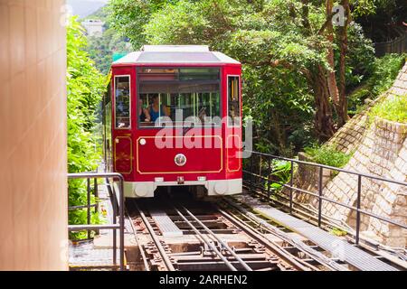 Hong Kong - 15 juillet 2017 : le train par câble rouge avec passagers monte en montagne. Le Peak Tram est un funiculaire de la ville de Hong Kong Banque D'Images