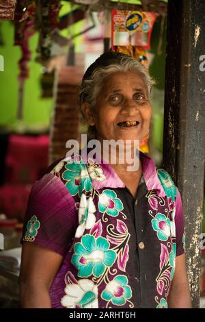 Femme locale commerçant, à l'entrée du magasin, province de Sabaragamuwa, près De La Réserve forestière de Sinharaja, Sri Lanka Banque D'Images