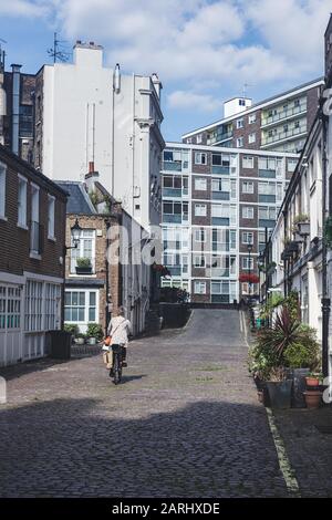 Londres/UK - 22/07/19: Une femme est en vélo dans un Mews à Bayswater, un quartier riche de la Cité de Westminster. C'est aussi l'un des mois de Londres Banque D'Images