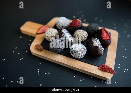 ensemble de bonbons à la main aux fruits et au chocolat sur une planche de bois Banque D'Images