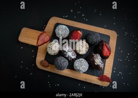 Vue de dessus d'un ensemble de bonbons à la main aux fruits et au chocolat sur une planche de bois Banque D'Images