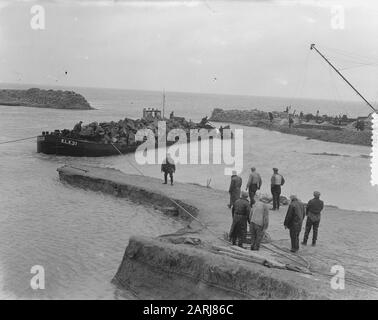Watersnood 1953] le trou de digue près de Herkingen op Goeree-Overflakkee, qui a été fait au début de février 1953, mais qui n'a pas été fermé à temps, est maintenant fermé avec des blocs de basalte. Les barges de grenier avec ces blocs sont navigué dans le trou, et à grande vitesse les morceaux de basalte sont ensuite jetés dans l'eau. Date : 12 Mars 1953 Lieu : Goeree-Overflakkee, Herkingen, Zuid-Holland Mots Clés : Restaurations, Inondations Banque D'Images