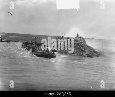 Watersnood 1953] le trou de digue près de Herkingen op Goeree-Overflakkee, qui a été fait au début de février 1953, mais qui n'a pas été fermé à temps, est maintenant fermé avec des blocs de basalte. Les barges de grenier avec ces blocs sont navigué dans le trou, et à grande vitesse les morceaux de basalte sont ensuite jetés dans l'eau. Date : 12 Mars 1953 Lieu : Goeree-Overflakkee, Herkingen, Zuid-Holland Mots Clés : Restaurations, Inondations Banque D'Images