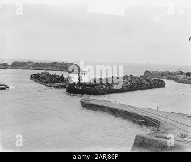 Watersnood 1953] le trou de digue près de Herkingen op Goeree-Overflakkee, qui a été fait au début de février 1953, mais qui n'a pas été fermé à temps, est maintenant fermé avec des blocs de basalte. Les barges de grenier avec ces blocs sont navigué dans le trou, et à grande vitesse les morceaux de basalte sont ensuite jetés dans l'eau. Date : 12 Mars 1953 Lieu : Goeree-Overflakkee, Herkingen, Zuid-Holland Mots Clés : Restaurations, Inondations Banque D'Images