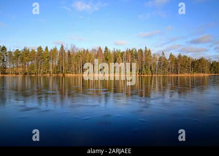 Petit lac rural Sorvasto à Salo, en Finlande, recouvert de glace mince lors d'une journée d'hiver ensoleillé avec un ciel bleu brillant. 25 Janvier 2020. Banque D'Images