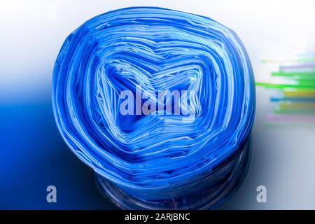 rouleau de sacs à ordures en plastique en bleu sur un fond coloré Banque D'Images