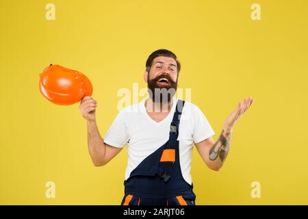 Sentez le soulagement. Enfin. Tendance de l'environnement technique. Casque de chantier. Amélioration et rénovation. Homme de construction brutal. Employé de type barbu sur fond jaune. Uniforme du constructeur ingénieur. Décoration de la maison. Banque D'Images