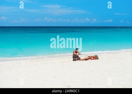 Tourisme prenant photo à la mer en vacances tropicales. Couple de voyageurs appréciant sur la plage. Banque D'Images