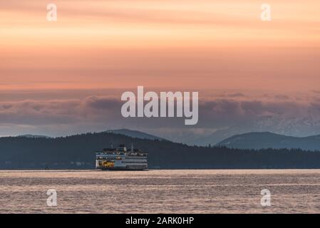 Ferry de l'État de Washington traversant Puget Sound au crépuscule avec les montagnes olympiques au-delà, de Seattle, Washington Banque D'Images