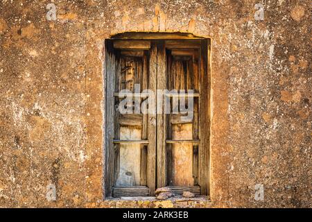 Italie, Sicile, Province De Messine, Novara Di Sicilia. Une fenêtre à volets délavés dans un ancien bâtiment de la ville médiévale de Francavilla di Sic Banque D'Images