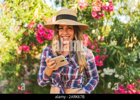 portrait de la jeune femme avec téléphone dans sa main vêtue de chéquier Banque D'Images