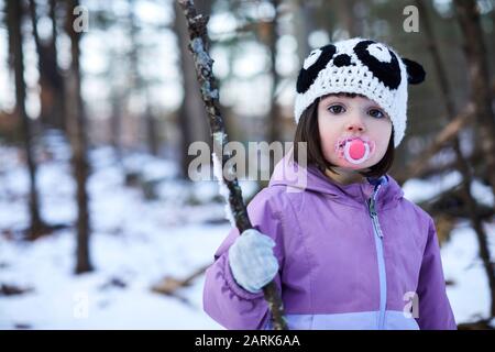 Un portrait d'hiver d'une petite fille dans les bois. Banque D'Images