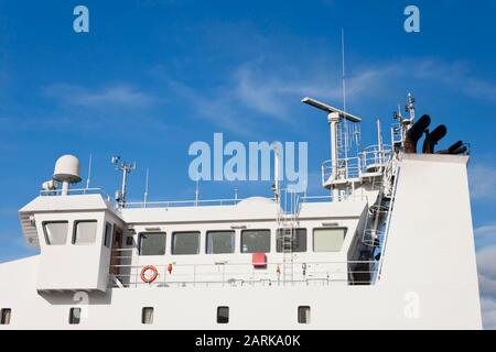 Tour de guet, antennes, radar, anémomètre et autres équipements de communication et de navigation sur le pont de commande d'un navire. Banque D'Images