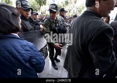 La Paz, La Paz, Bolivie. 28 janvier 2020. Un agent de police de l'unité anti-émeute tente de convaincre les personnes qui attendent à l'extérieur du palais présidentiel de s'éloigner lors de la désignation de nouveaux ministres à la Paz, en Bolivie. Le lundi 27 janvier, la présidente bolivienne Añez demande à tous ses ministres de renoncer, le lendemain de sa nomination de trois nouveaux ministres et de confirmer les 17 autres dans leurs positions. Crédit: Christian Lombardi/Zuma Wire/Alay Live News Banque D'Images