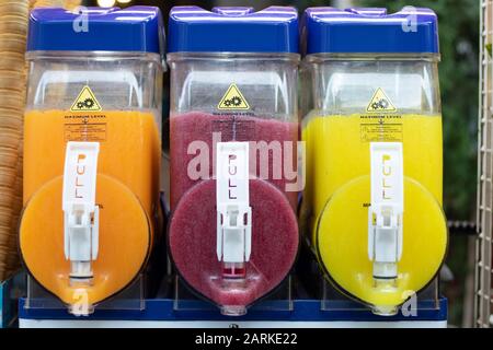 Machine à jus de fruits. Il existe 3 types différents de jus de fruits. La machine mélange les jus. Banque D'Images