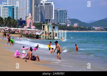 Vous pourrez profiter de la promenade et de la plage de la station balnéaire de Nha Trang au Vietnam, en Asie du Sud-est, à Indochina, en Asie, par une journée chaude et ensoleillée. En ce qui concerne la barge à l'arrière-plan: En décembre 2019, une barge de ferry portant le numéro KH-98668-TS a dérivé et a été lavée à la plage de Nha Trang et est encore bloquée sur le sable à l'est de la rue Tran Phu, Nha Trang, le 29 janvier 2020. Banque D'Images