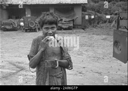 Photo Reportage Palembangs Mimmed indonésien homme mange sandwich et regarde dans sa main Date: Janvier 1947 lieu: Indonésie, Hollandais East Indies, Palembangs, Sumatra Banque D'Images
