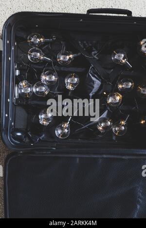 fuite des cerveaux concept de la vie, valise ouverte avec une chaîne d'ampoules allumé symbole de personnes hautement formées déplacer le pays pour améliorer leur Banque D'Images