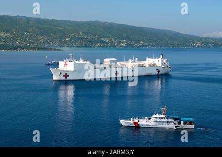 USCGC Margaret Norvell (WPC 1105), front, et USCGC Kathleen Moore (WPC 1109) naviguent le long du navire hospitalier USNS Comfort (T-AH 20) car il est ancré au large de la côte de Port-au-Prince, Haïti en préparation d'une mission médicale de six jours, le 4 novembre 2019. Comfort travaille avec des partenaires de santé et de gouvernement en Amérique centrale, en Amérique du Sud et dans les Caraïbes pour fournir des soins sur le navire et sur les sites médicaux terrestres, aidant à soulager la pression sur les systèmes médicaux nationaux, y compris ceux qui sont tendus par une augmentation des migrants transfrontaliers. (ÉTATS-UNIS Photo marine par le spécialiste de la communication de masse 2ème Cla Banque D'Images