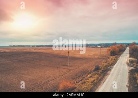 Vue aérienne sur la campagne. Route nationale directe et champs arables en automne soir Banque D'Images