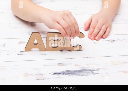 Mains de l'enfant contenant des lettres ABC. Concept d'éducation. Banque D'Images