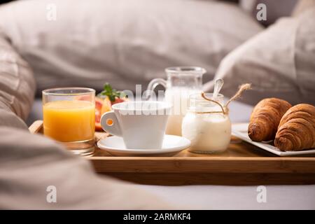 Petit-déjeuner continental. Plateau de petit-déjeuner au lit avec café, jus d'orange et croissant près Banque D'Images