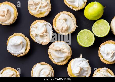 Tartelettes de meringue au citron à base de chaux isolées sur la surface noire - photo en hauteur Banque D'Images