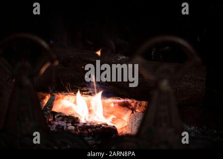 Flammes et coals chauds dans un feu brûlant dans une cheminée dans une vue rapprochée sélective de mise au point pour la chaleur et la relaxation en hiver Banque D'Images
