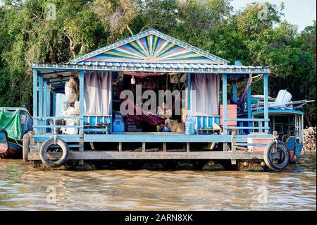 Maisons flottantes Tonle Sap. Jeune femme sur téléphone mobile, se détendre dans hamac Banque D'Images