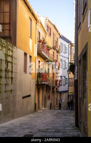 Porto, Portugal - 20 janvier 2020: Les touristes flânent dans les rues étroites et les ruelles avec des bâtiments colorés et une architecture unique Banque D'Images