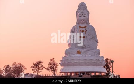 Statue de Bouddha sur l'arrière-plan du ciel du soir de teintes roses; temple bouddhiste Wat Hyua Pla Kang au coucher du soleil à Chian Rai, Thaïlande Banque D'Images