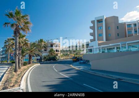 Il-Mellieha, Malte - Janvier 2020 : intersection De La route Du Rond-Point avec des palmiers et des maisons résidentielles sur la rue de la petite station touristique v Banque D'Images