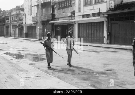 Retrait des troupes néerlandaises de Solo, Gondang Winangoe et Klaten Deux soldats de l'INT en hélices traversent une rue vide avec leurs armes dans l'attaque Annotation: DJK Date: 12 novembre 1949 lieu: Indonésie, Java, Hollandais East Indies Banque D'Images