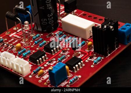 Carte de circuit imprimé rouge gros plan sur fond noir Banque D'Images