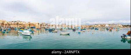 Marsaxlokk, Malte – Janvier 2020 : bateaux traditionnels colorés à yeux Luzzu dans le port du village de pêche méditerranéen Banque D'Images