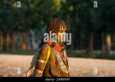 Hamer femme traversant la route dans le village de Dimeka, vallée de la rivière Omo, Ethiopie. Banque D'Images