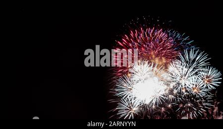 Plusieurs feux d'artifice en étoile rouge, blanc et bleu ont été photographiés contre un ciel noir le 4 juillet au Minnesota Banque D'Images