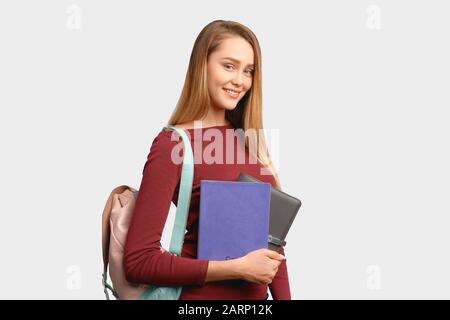 une fille souriante tient des carnets en cuir à portée de main Banque D'Images