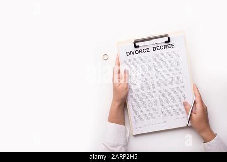 Femme lisant le décret de divorce avant de signer sur blanc Banque D'Images